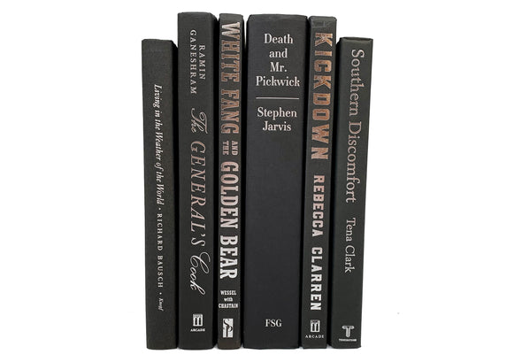Silver foil lettered black decorative books. Color-coded book stack by the shelf foot