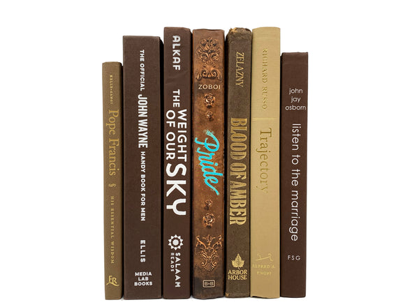 earth toned brown, tan, chocolate decorator books. Color-coded book stack by the shelf foot. 