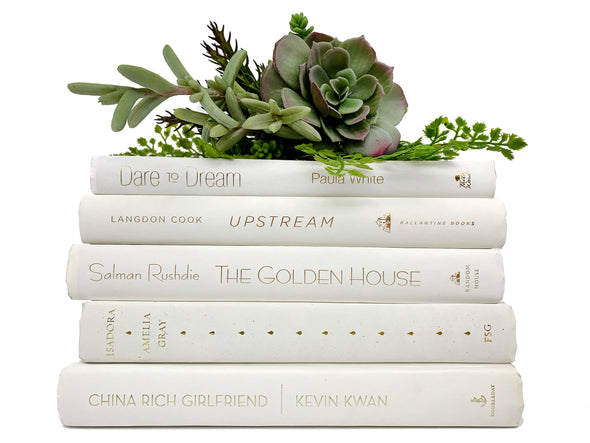 White decorative books. Color-coded book stack by the shelf foot.