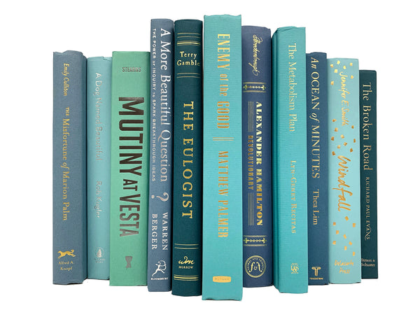 beachy coastal green and blue decorator books. Color-coded book stack by the shelf foot. 